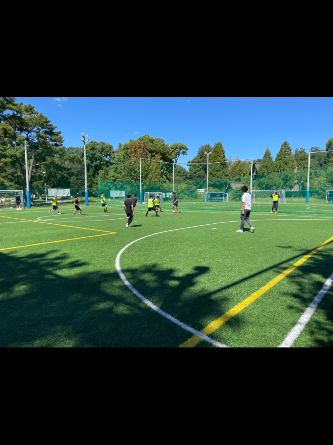 青空の下、服部緑地公園のピッチで練習する関西ユナイテッドFCのメンバー